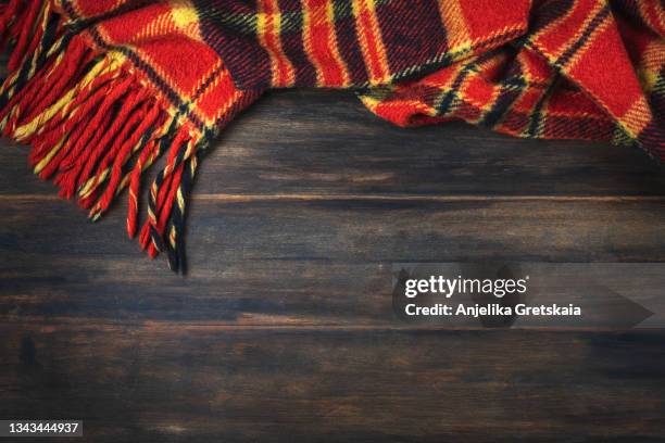 checkered plaid on wooden background - red scarf stock-fotos und bilder