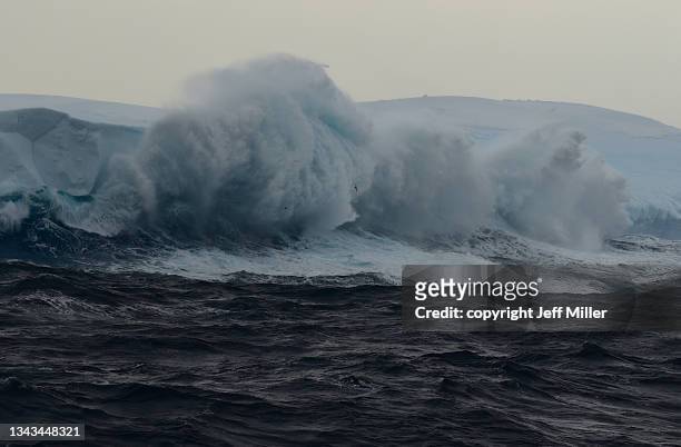 dramatic wave crashing against iceberg sends spray into the sky, southern ocean, antarctica. - breaking the ice photos et images de collection