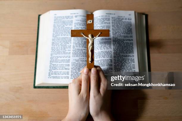 cross on bible ; pray for god - priest stock-fotos und bilder