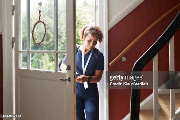 healthcare worker arriving at home - woman entering home stock-fotos und bilder