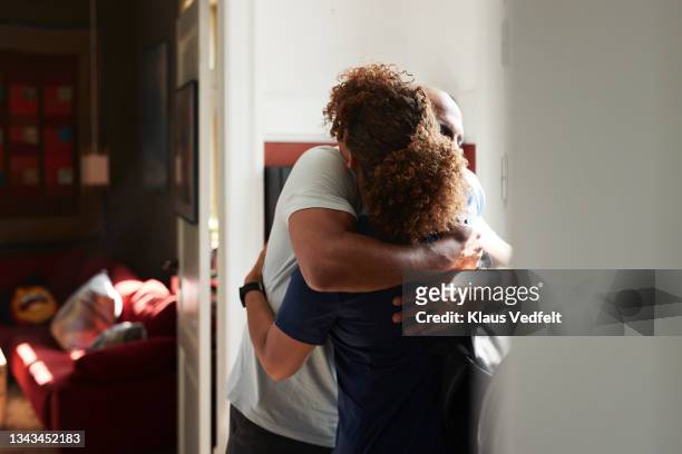 caregiver embracing man at home - embracing stock pictures, royalty-free photos & images