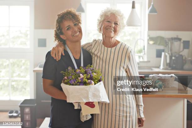 smiling female caregiver and senior woman - elderly receiving paperwork stock pictures, royalty-free photos & images
