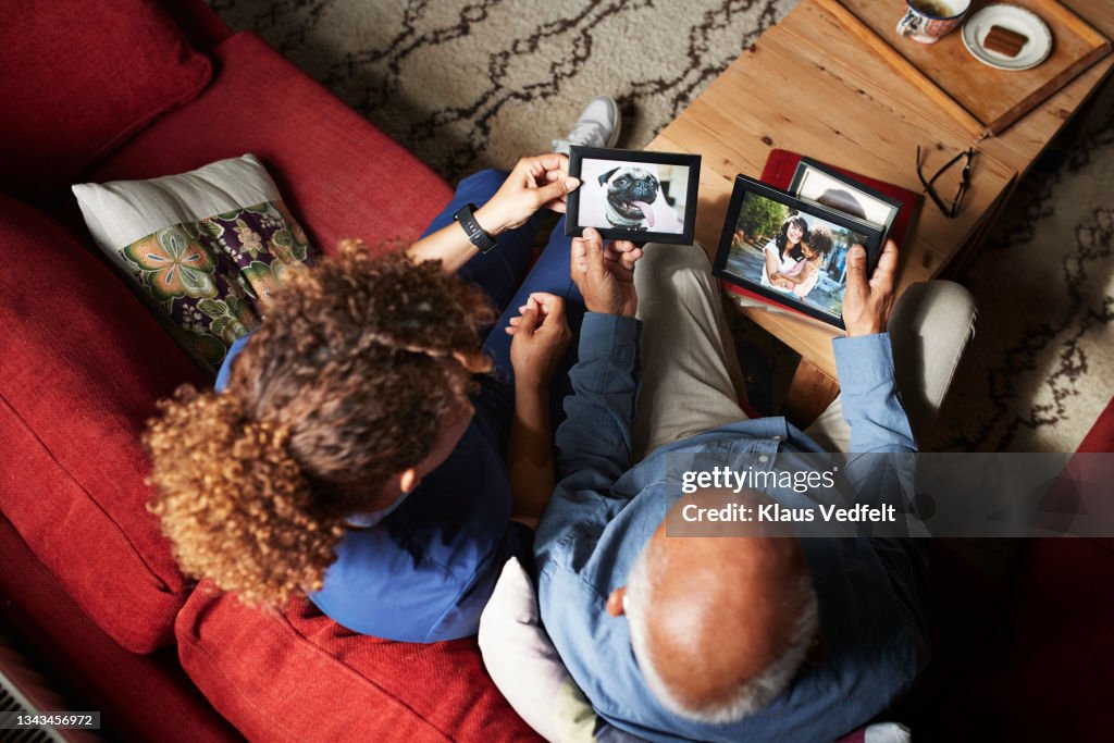 Senior man showing picture frames to nurse