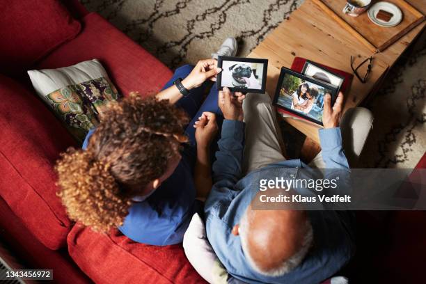 senior man showing picture frames to nurse - memories stock pictures, royalty-free photos & images