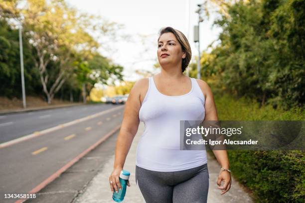 mulher andando no parque da cidade - fat - fotografias e filmes do acervo