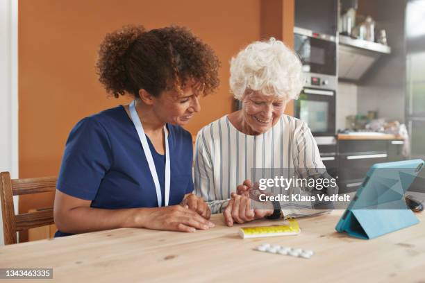 retired woman learning smart watch from caregiver - smart watch stock pictures, royalty-free photos & images