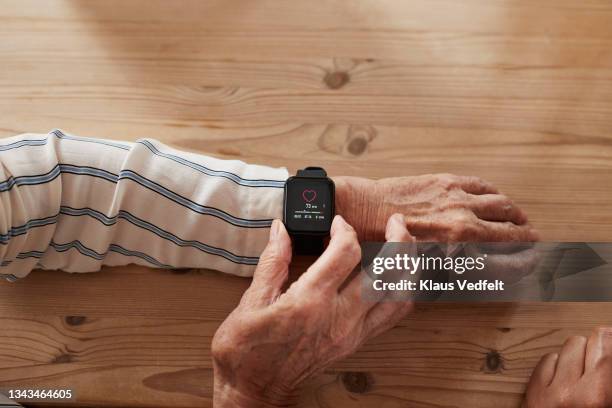 woman wearing smart watch at table - smartwatch stock-fotos und bilder