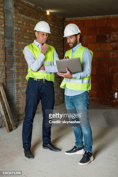 ingenieros civiles que trabajan en una computadora en el sitio de construcción. - ingeniero civil fotografías e imágenes de stock