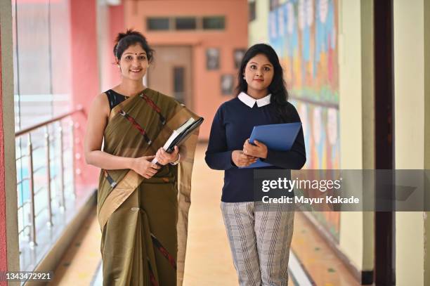 portrait of school teachers standing in the school building corridor - teacher with folder stock pictures, royalty-free photos & images