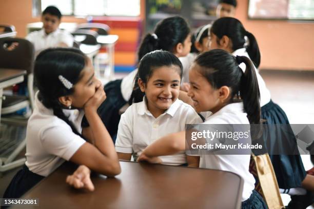 school girls talking in groups in a classroom during break - indian school students ストックフォトと画像
