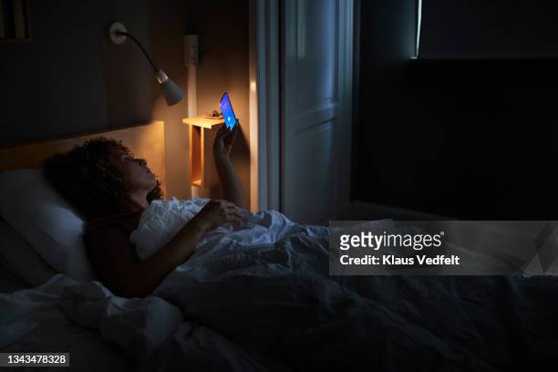 woman waking up through alarm ring on smart phone - good morning ストックフォトと画像