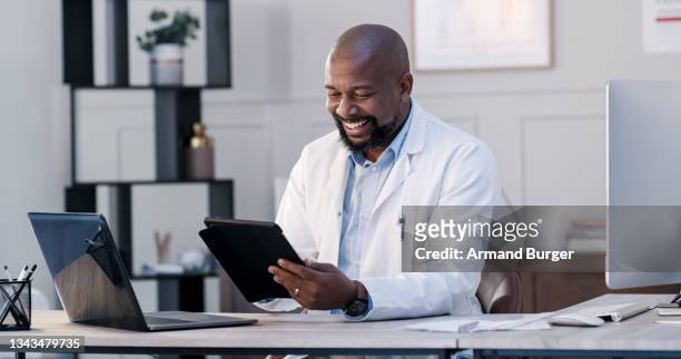 shot of a male doctor using his digital tablet in his office - male medical professional bildbanksfoton och bilder