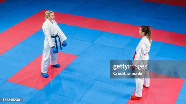 karatespielerinnen stehen sich auf tatami gegenüber - tatami matte stock-fotos und bilder