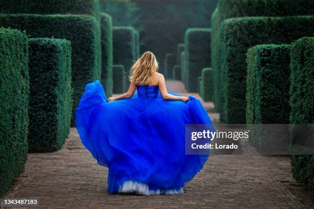 a beautiful blonde adult princess in a secret garden setting - fairytale princess stock pictures, royalty-free photos & images