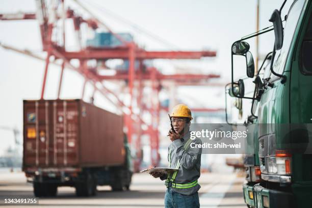 arbeiter, der walkie-talkie im kommerziellen dock verwendet - dock stock-fotos und bilder