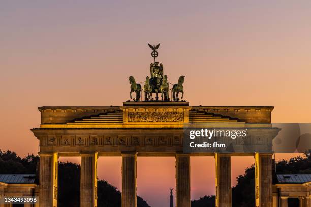 brandenburg gate at sunset (berlin, germany) - quadriga statue brandenburg gate stock-fotos und bilder