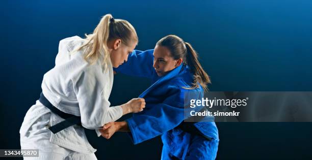 jugadora de judo que intenta agarrar al oponente en la pelea - women's judo fotografías e imágenes de stock