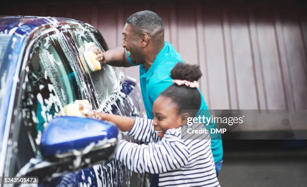 shot of a father and his daughter washing their car outside - lavar imagens e fotografias de stock
