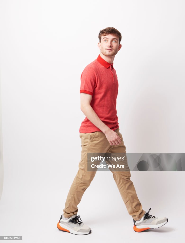 Young man walking through a space in a carefree way