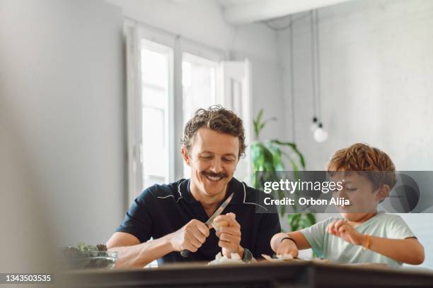 father and son cutting potatoes - single father stock pictures, royalty-free photos & images