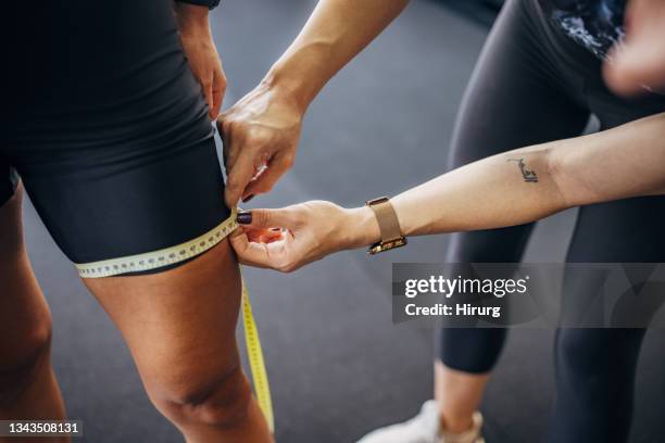 fit woman measuring her thigh - measure waist stock pictures, royalty-free photos & images