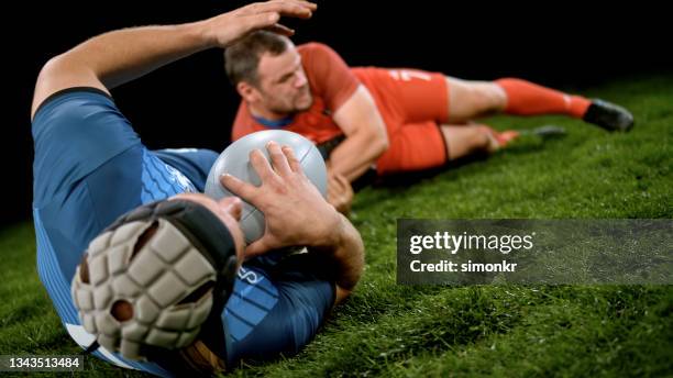 rugby player tackling his opponent - headwear stock pictures, royalty-free photos & images