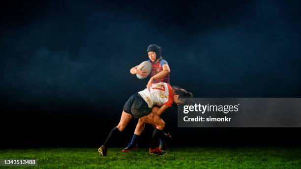 rugby player tackling her opponent - rugby tackle stockfoto's en -beelden