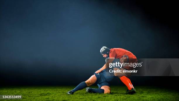 rugby player tackling his opponent - rugby tackle stockfoto's en -beelden