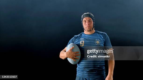 nahaufnahme des rugbyspielers im stehen mit ball - rugby portraits stock-fotos und bilder