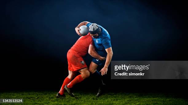 rugby player tackling his opponent - tackelen stockfoto's en -beelden
