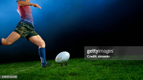 joueur de rugby donnant un coup de pied au ballon - stade rugby photos et images de collection
