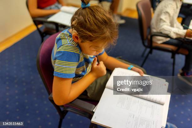 male student with cochlear implant in the classroom - cochlear implant stock pictures, royalty-free photos & images