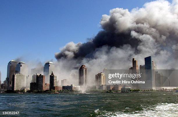 Smoke rises over the New York Skyline from the scene of the World Trade Center Attack, as seen from a tugboat evacuating people from Manhattan to New...