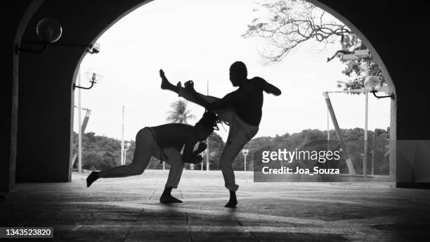 apoeristas are seen in a capoeira roda - berimbau stock pictures, royalty-free photos & images