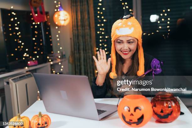 the woman with the halloween costume video chat with her family via laptop computer - halloween covid stock pictures, royalty-free photos & images