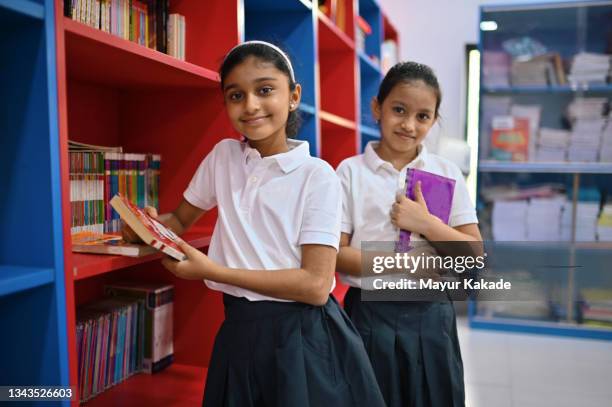 portrait of school girls with book in a school library - maharashtra stock pictures, royalty-free photos & images