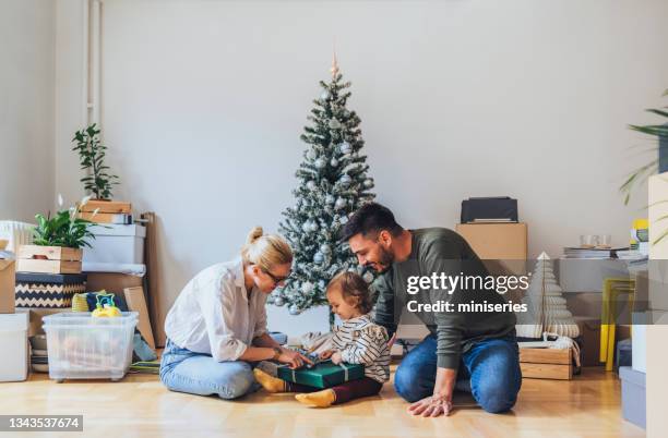 mother and father giving christmas present to their cute daughter - homeowners decorate their houses for christmas stock pictures, royalty-free photos & images