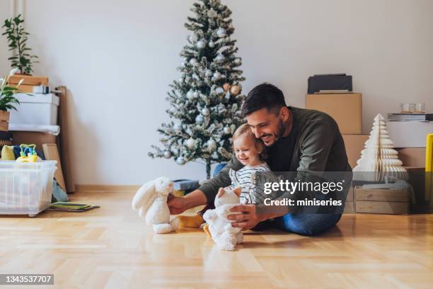 playful father with his cute daughter at home - homeowners decorate their houses for christmas stockfoto's en -beelden