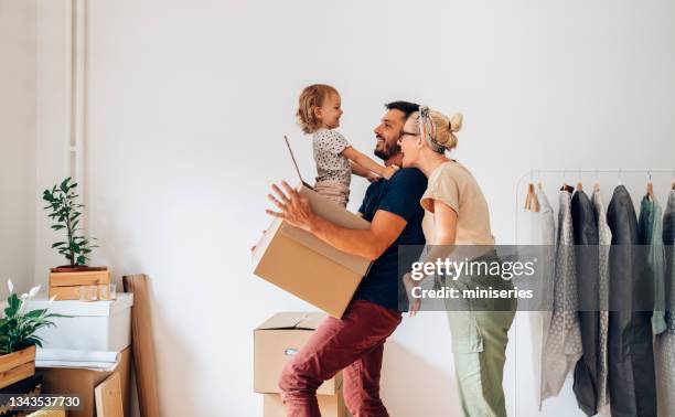 famiglia allegra che si trasferisce in una nuova casa - attività fisica foto e immagini stock