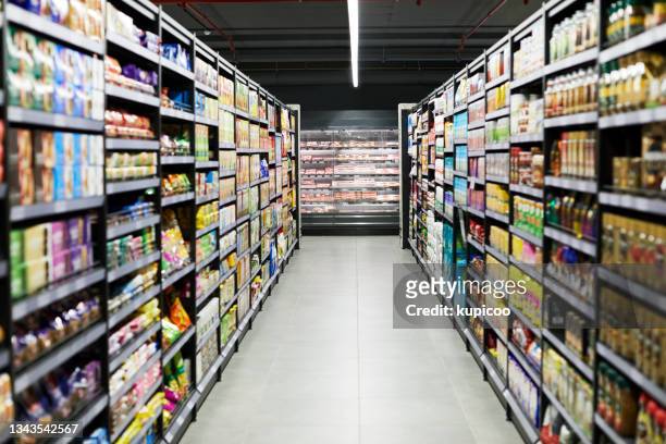 shot of a empty aisle in a supermarket - 貯物架 個照片及圖片檔