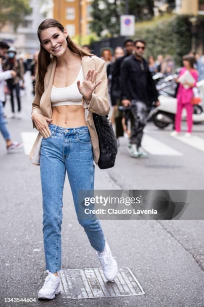 Grace Elizabeth, wearing a white crop top, beige blazer and blue jeans, poses ahead of the Max Mara fashion show during the Milan Fashion Week -...
