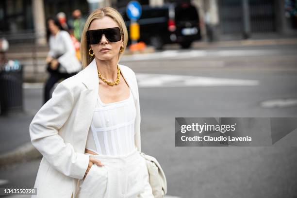 Elizabeth Sulcer, wearing a white top, white suit and white bag, poses ahead of the Max Mara fashion show during the Milan Fashion Week - Spring /...