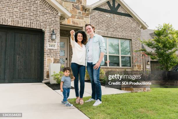 family proudly displays house key after purchasing home - homeowner stockfoto's en -beelden
