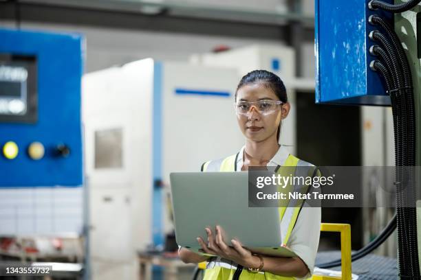 reduce machine downtime in manufacturing industry. asian female maintenance engineer using laptop in side of an automated machine in the production line while monitoring machine with connecting to pm software and keep record data. - laptops in a row stock pictures, royalty-free photos & images