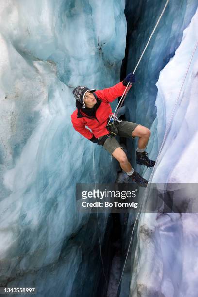 mountaineer abseiling in glacier crevasse - bo tornvig photos et images de collection