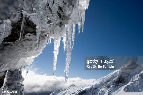 icicles on rocks in snow covered mountain - bo tornvig photos et images de collection