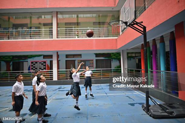 school children playing basketball in basketball court in school - sports india stockfoto's en -beelden