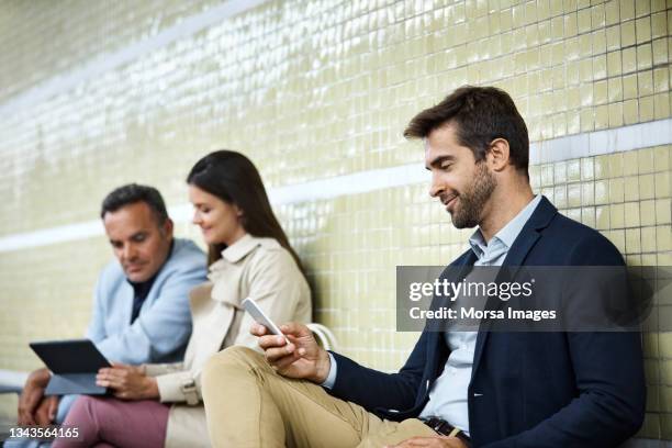 businessman using smart phone at subway station - railway station platform stock pictures, royalty-free photos & images