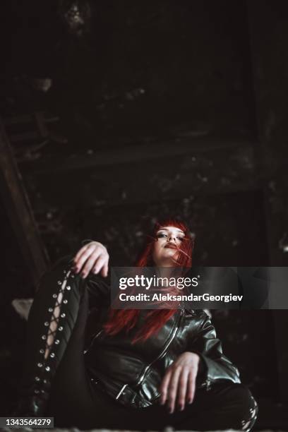 vista de ángulo bajo de una mujer goda en cuclillas en ruinas de edificios - heavy metal door fotografías e imágenes de stock