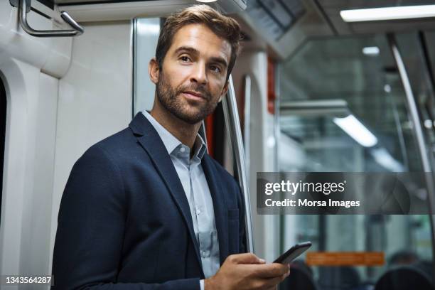 businessman traveling in subway train - bart zug stock-fotos und bilder